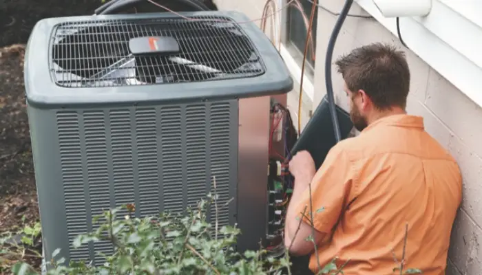 Tech working on air conditioner emergency repair