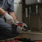 Plumber works on the kitchen sink drain