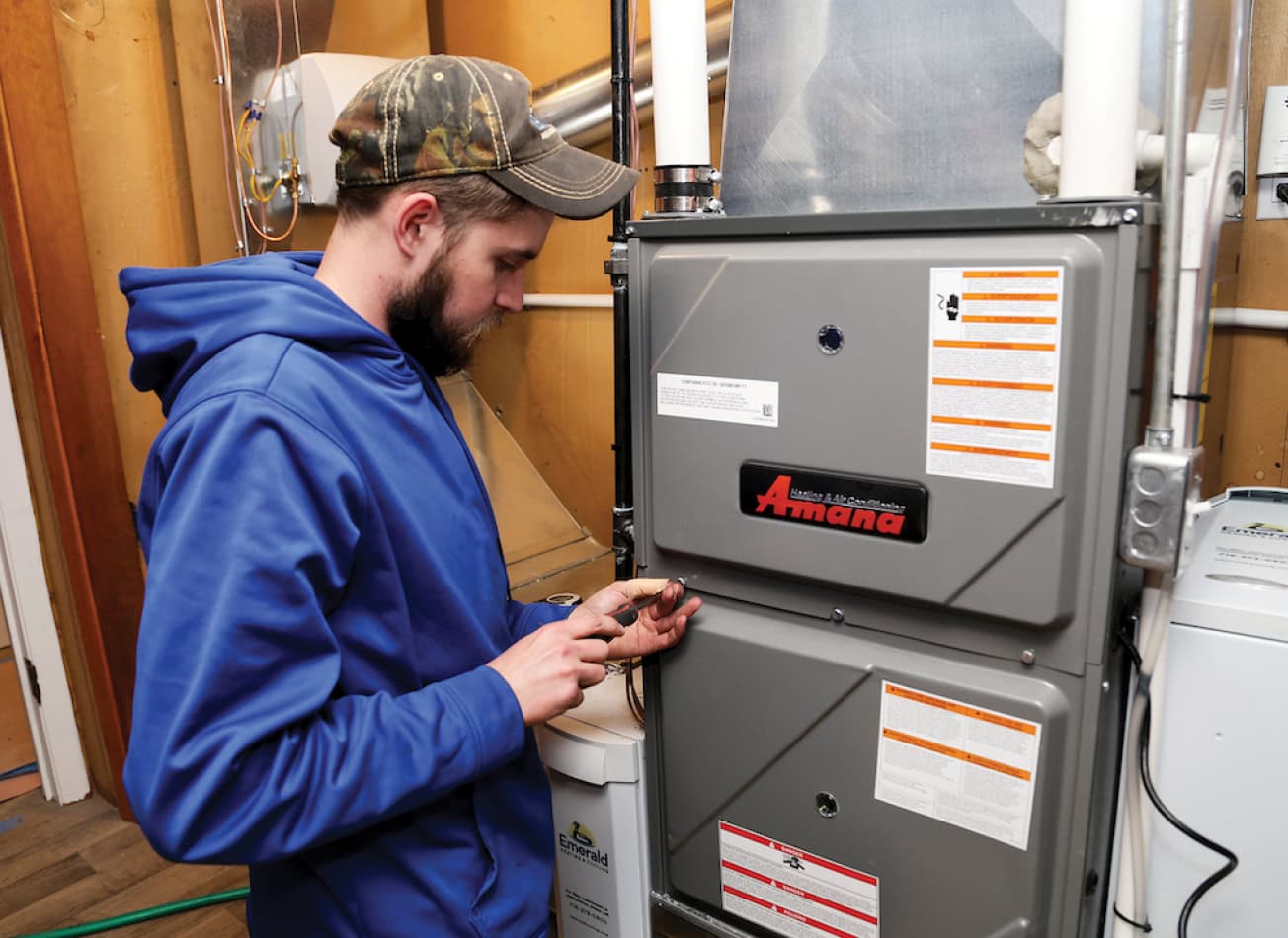 PDM Plumbing, Heating & Cooling HVAC technician installing a new Amana furnace.