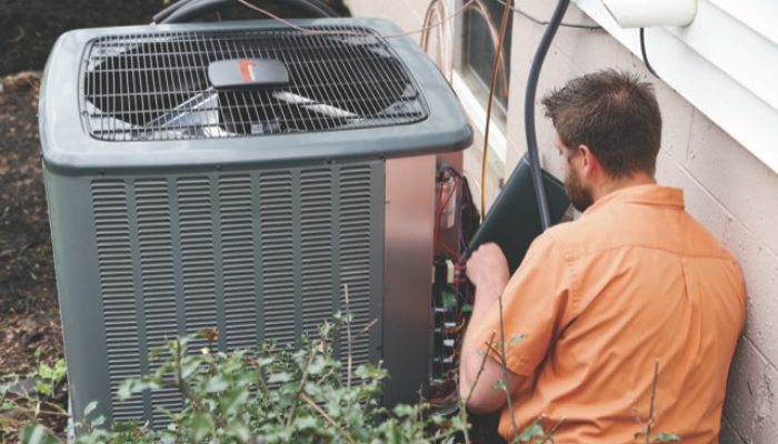 Tech working on air conditioner emergency repair