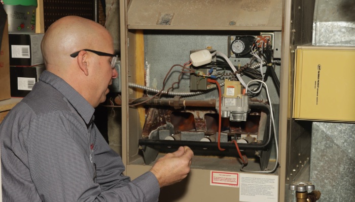 PDM Technician Working On Furnace Repair