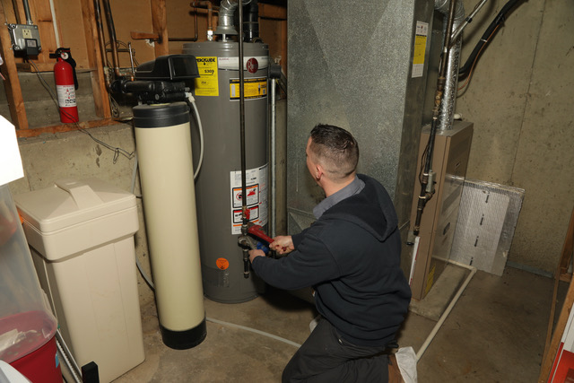 Plumber working on water heater and water softener