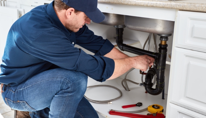 Plumber Working Under Kitchen Sink Fixing Leaking Water, Broken Kitchen Drain